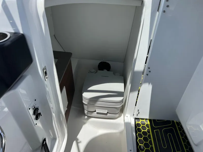 Slide: The Image of 2023 Scarab 255 Wake ID boat interior with compact portable toilet. - 47