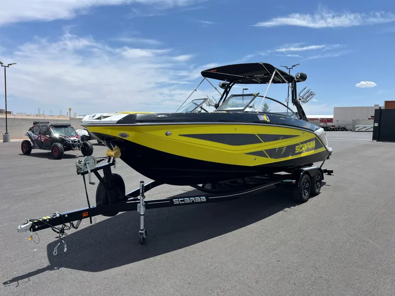 Slide: The Image of 2023 Scarab 255 Wake ID boat with yellow and black design on a trailer. - 6