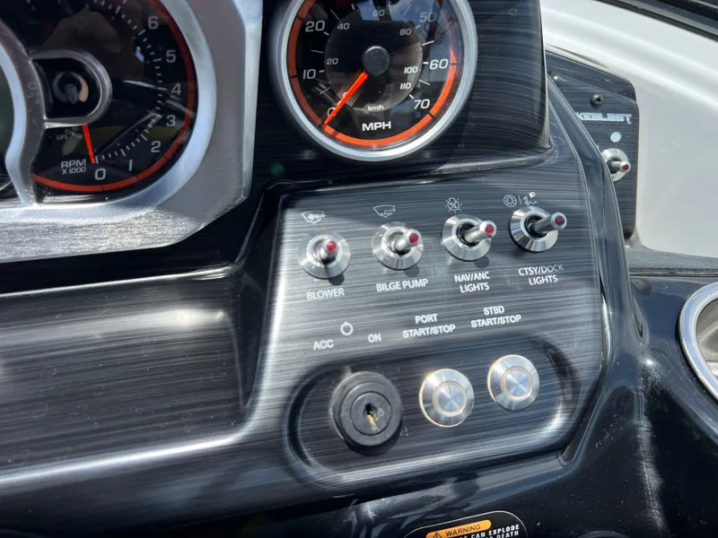 Slide: The Image of Dashboard controls of a 2023 Scarab 255 Wake ID boat with speedometer and switches. - 7