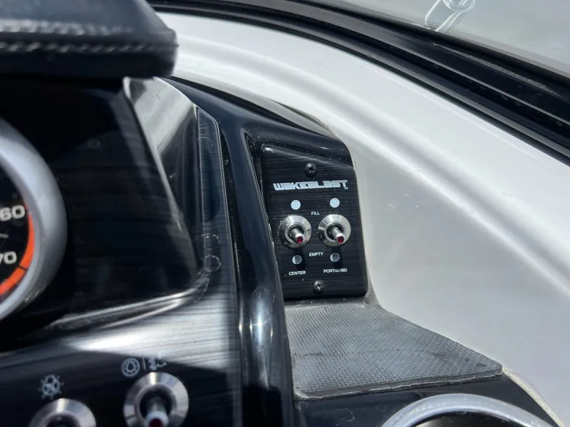 Slide: The Image of Dashboard controls of 2023 Scarab 255 Wake ID boat, featuring switches and gauges. - 8