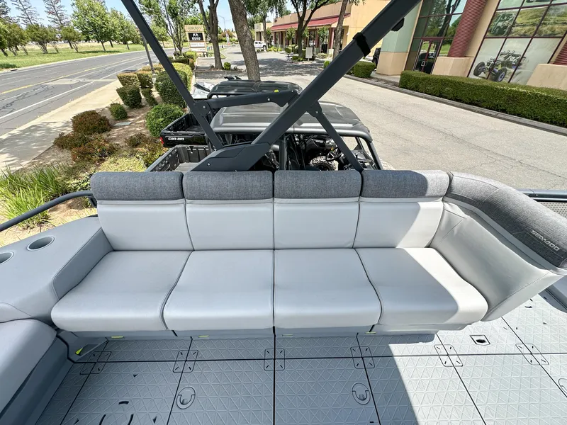 Slide: The Image of 2024 Sea-Doo Switch Sport 21 boat interior with gray seating and outdoor view. - 14
