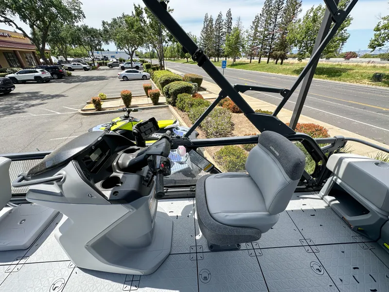 Slide: The Image of 2024 Sea-Doo Switch Sport 21 interior with steering console and seating, parked near a road. - 15