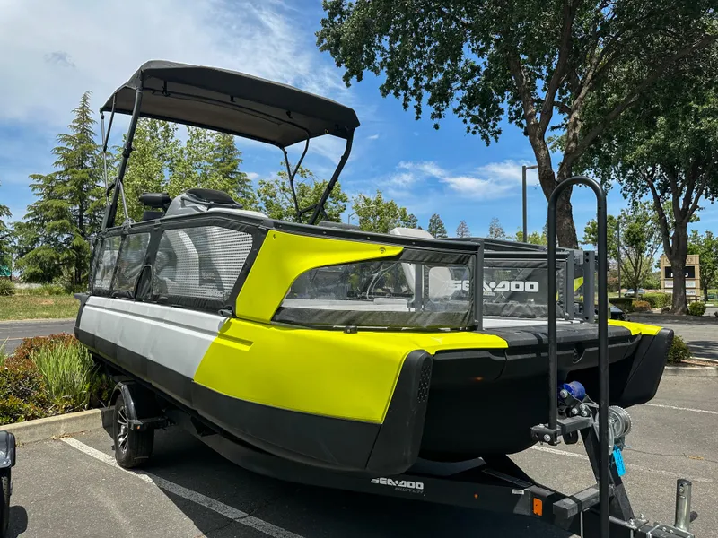 Slide: The Image of 2024 Sea-Doo Switch Sport 21 boat on trailer, parked outdoors under trees. - 18
