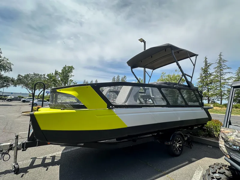 Slide: The Image of 2024 Sea-Doo Switch Sport 21 boat with vibrant yellow accents parked outdoors. - 20