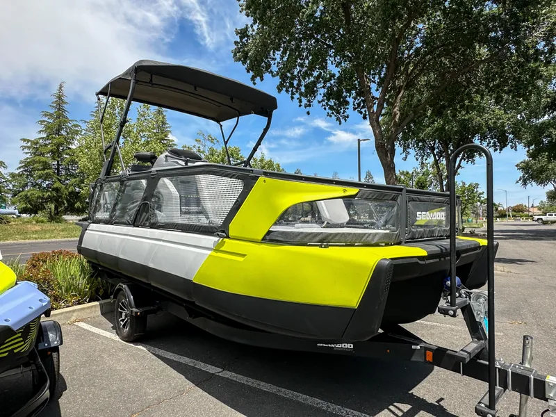 Slide: The Image of 2024 Sea-Doo Switch Sport 21 boat on trailer, parked outdoors under trees. - 4