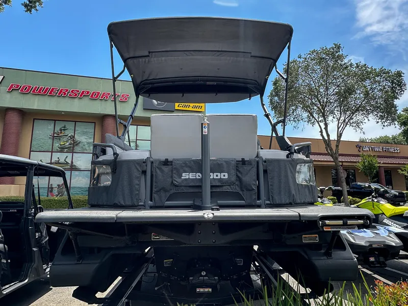 Slide: The Image of 2024 Sea-Doo Switch Sport 21 pontoon boat displayed outdoors at a powersports dealership. - 5