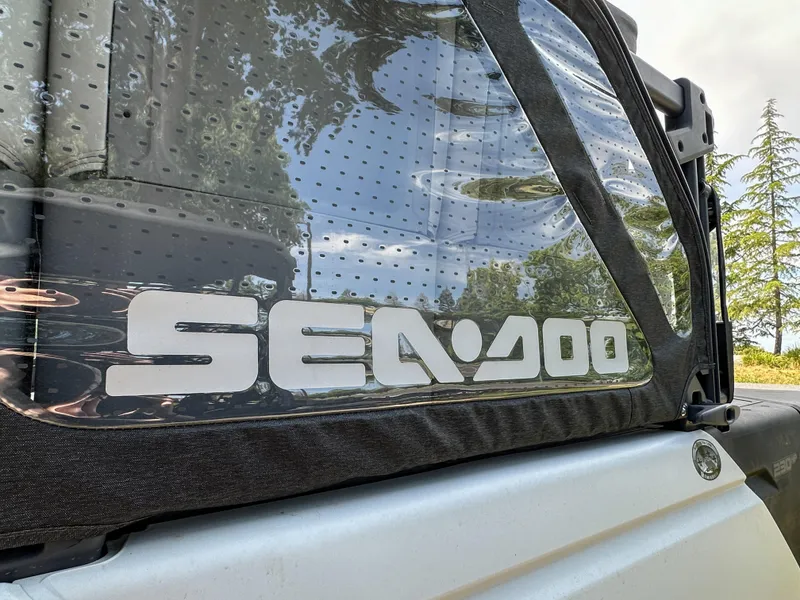 Slide: The Image of 2024 Sea-Doo Switch Sport 21 logo on a boat window with scenic reflection. - 6