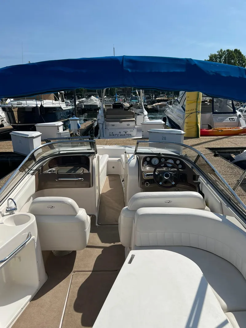 Slide: The Image of 2006 Regal 2600 Bowrider with blue canopy docked at marina. - 13