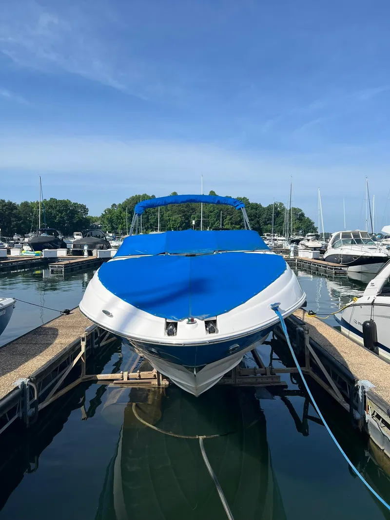 Slide: The Image of 2006 Regal 2600 Bowrider boat docked with blue cover in a marina. - 2