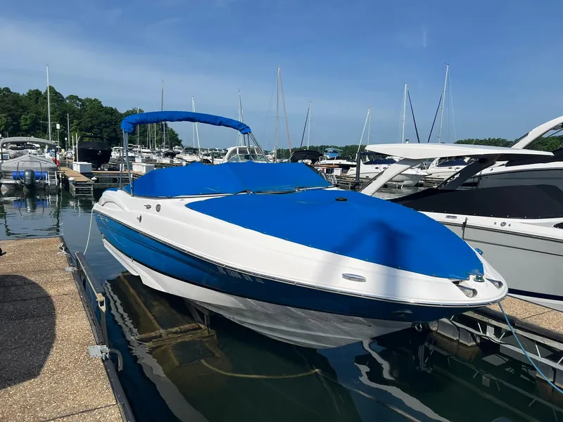 Slide: The Image of 2006 Regal 2600 Bowrider boat docked at marina with blue cover. - 3