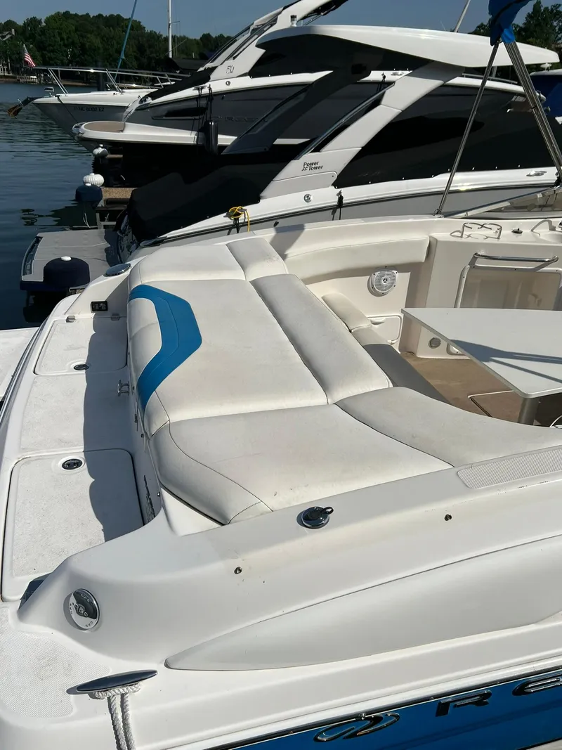 Slide: The Image of 2006 Regal 2600 Bowrider boat with white and blue seating docked at marina. - 7