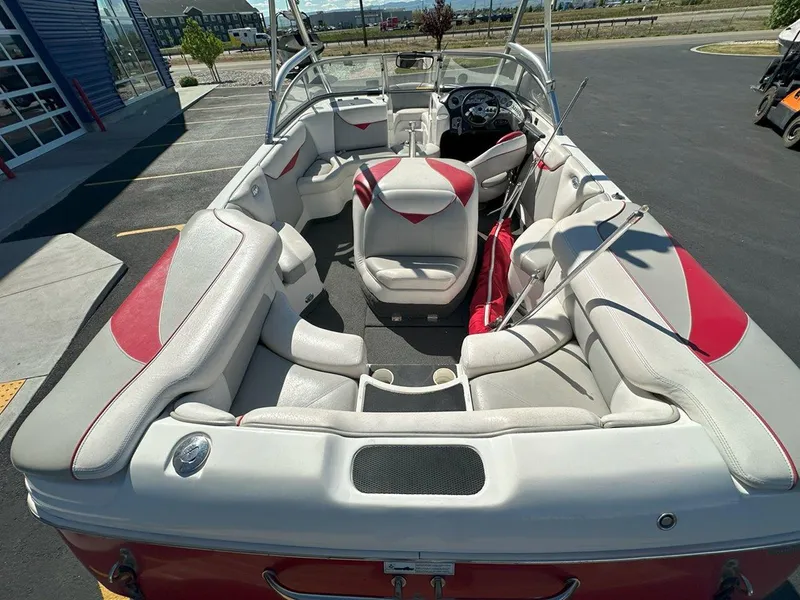 Slide: The Image of 2006 Tigé 22i boat interior with white and red seating, parked outdoors. - 10