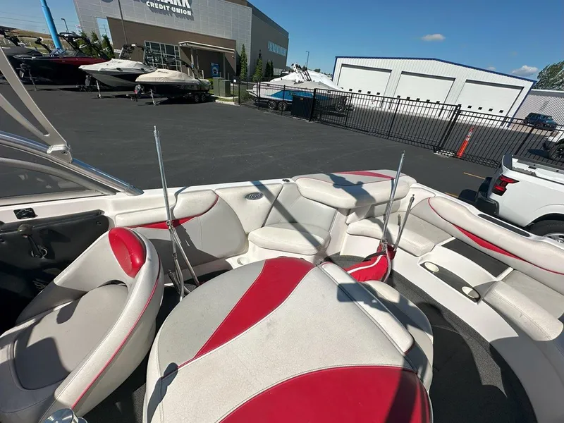 Slide: The Image of 2006 Tigé 22i boat interior with red and white seating, parked near a credit union. - 16