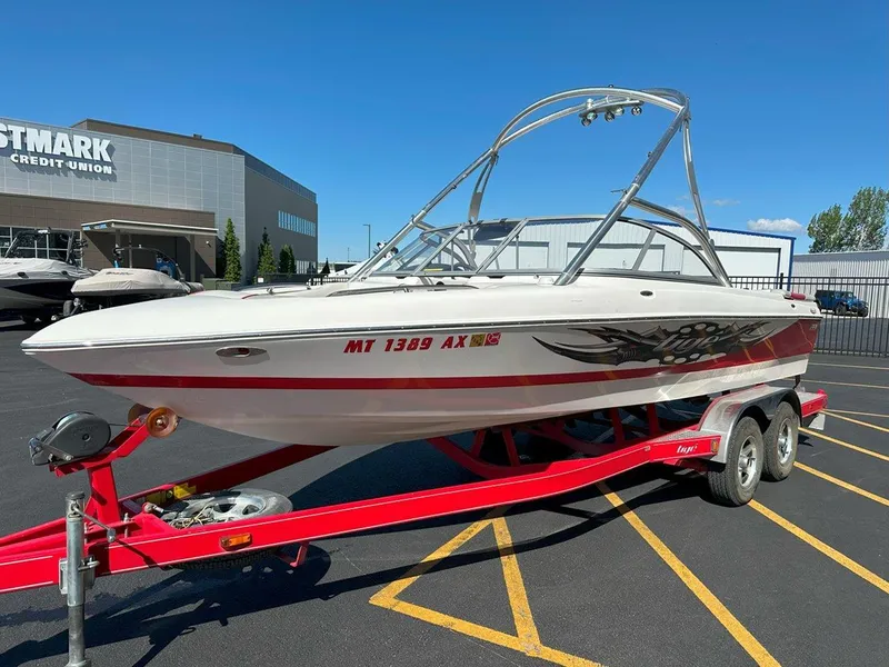 Slide: The Image of 2006 Tigé 22i boat on red trailer in parking lot, near credit union building. - 5