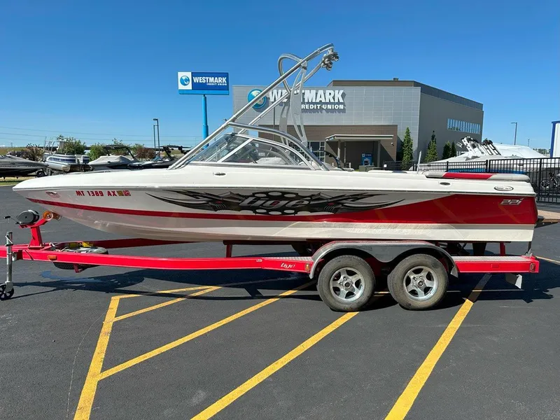 Slide: The Image of 2006 Tigé 22i boat on red trailer, parked at Westmark Credit Union. - 6