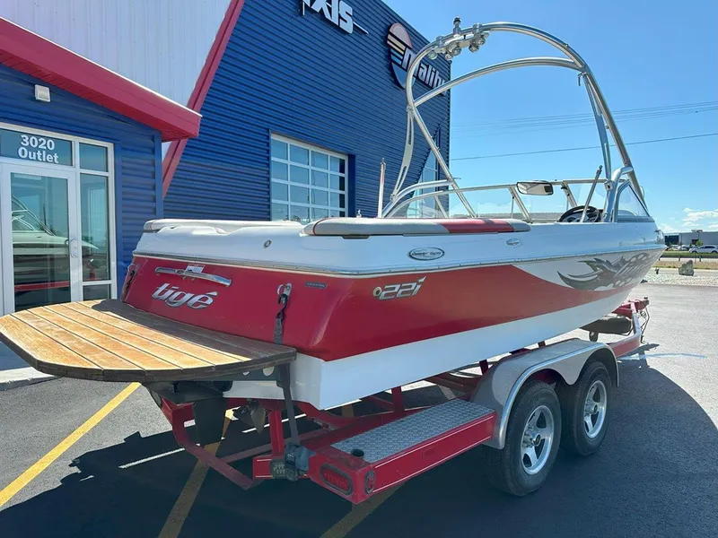 Slide: The Image of 2006 Tigé 22i boat on trailer outside dealership, red and white design. - 9