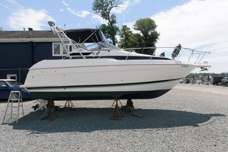 Slide: The Image of 1995 Wellcraft 2800 Martinique boat on stands in a gravel lot. - 0