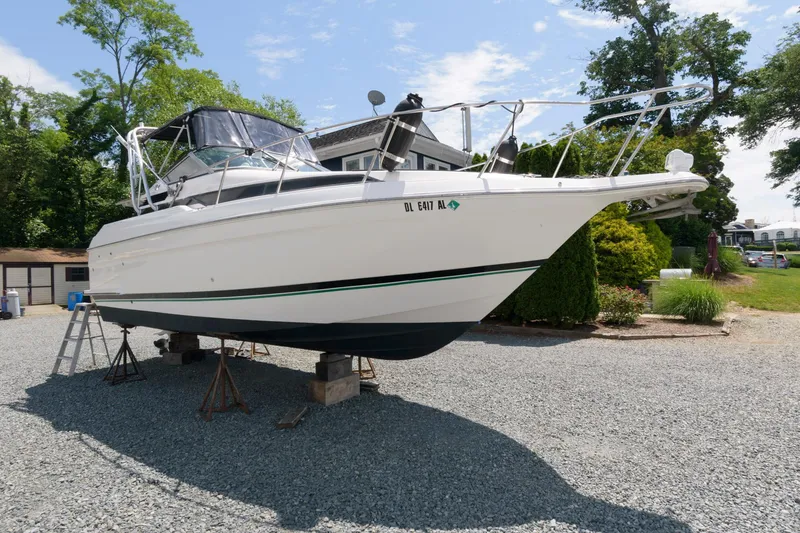 Slide: The Image of 1995 Wellcraft 2800 Martinique boat on dry dock in a gravel yard. - 1