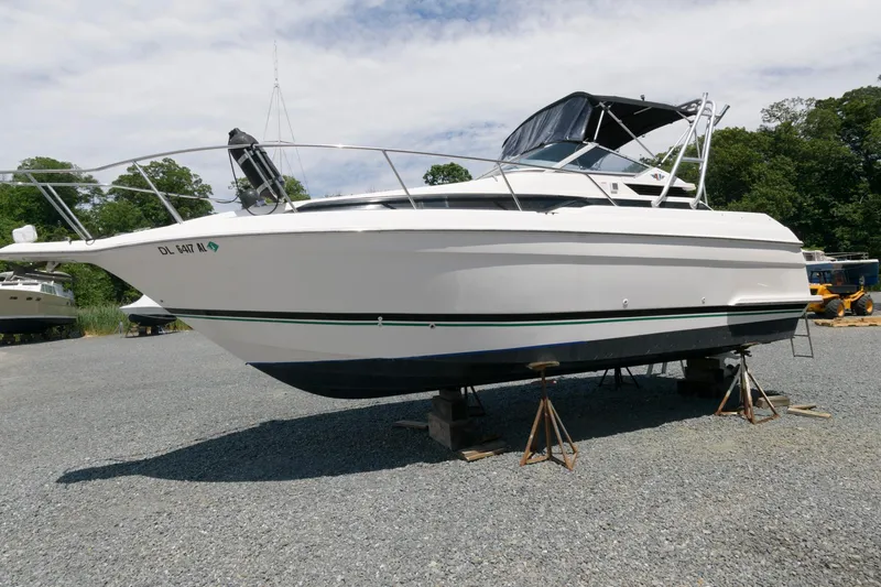 Slide: The Image of 1995 Wellcraft 2800 Martinique boat on stands in a gravel lot. - 2