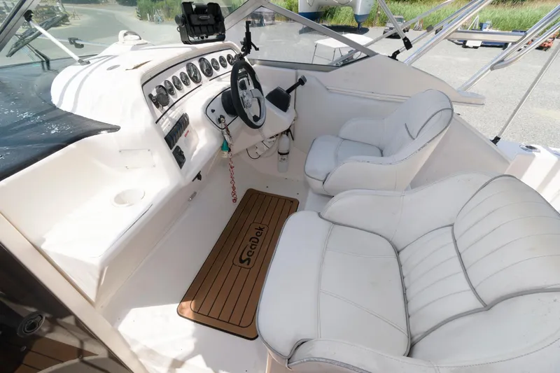 Slide: The Image of 1995 Wellcraft 2800 Martinique boat cockpit with white leather seats and wooden floor mat. - 4