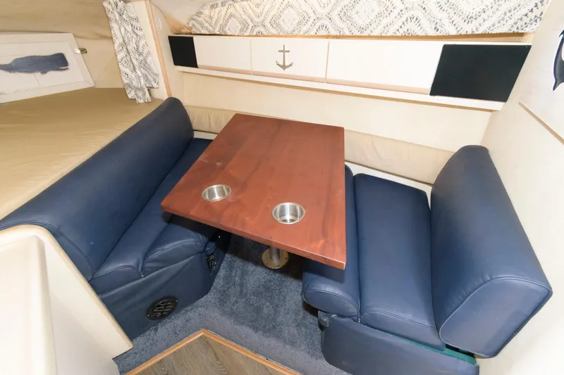 Slide: The Image of 1995 Wellcraft 2800 Martinique cabin interior with blue seating and wooden table. - 8