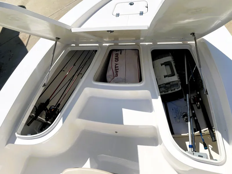 Slide: The Image of 2018 Robalo 206 Cayman boat storage compartments with fishing gear and safety equipment. - 22