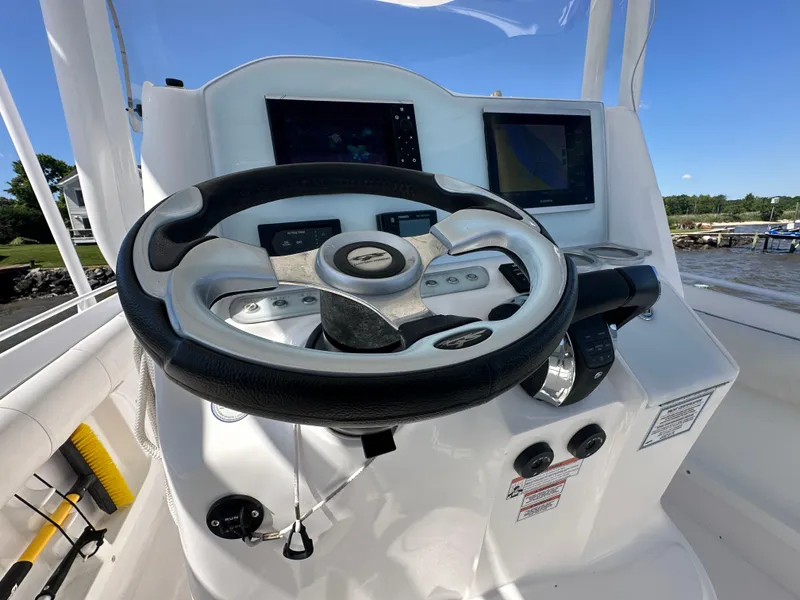 Slide: The Image of 2020 Glasstream 280 SCX boat helm with steering wheel and navigation screens. - 11