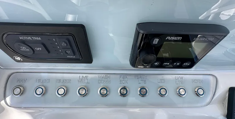 Slide: The Image of Control panel of a 2020 Glasstream 280 SCX boat with various switches and a Fusion MS-NRX300 unit. - 13