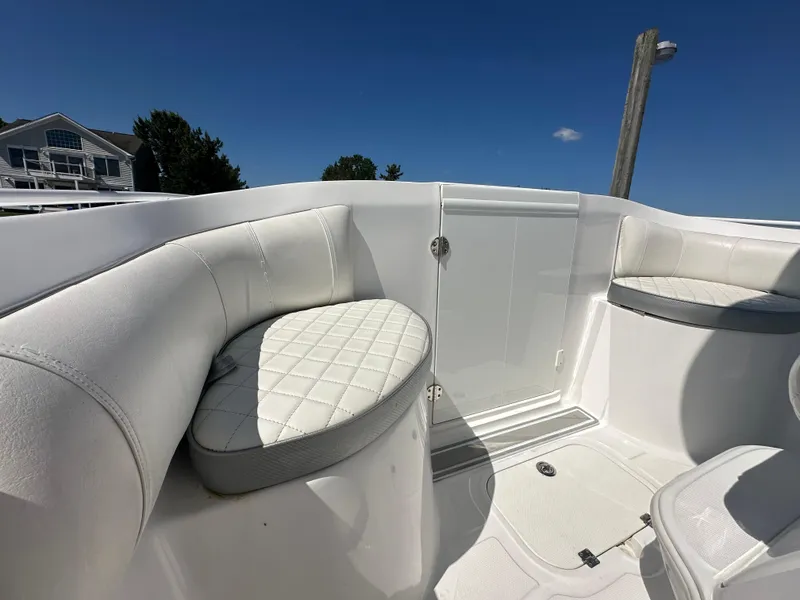 Slide: The Image of 2020 Glasstream 280 SCX boat interior with white cushioned seating under clear blue sky. - 22