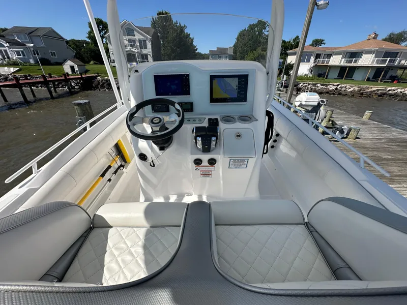 Slide: The Image of 2020 Glasstream 280 SCX boat cockpit with steering wheel, navigation screens, and cushioned seating. - 7