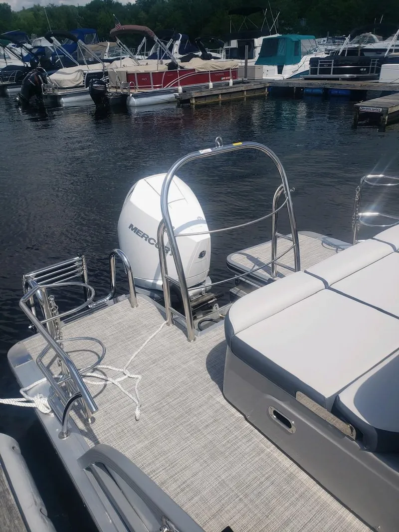 Slide: The Image of 2023 Harris Grand Mariner 230 pontoon boat docked at a marina. - 3