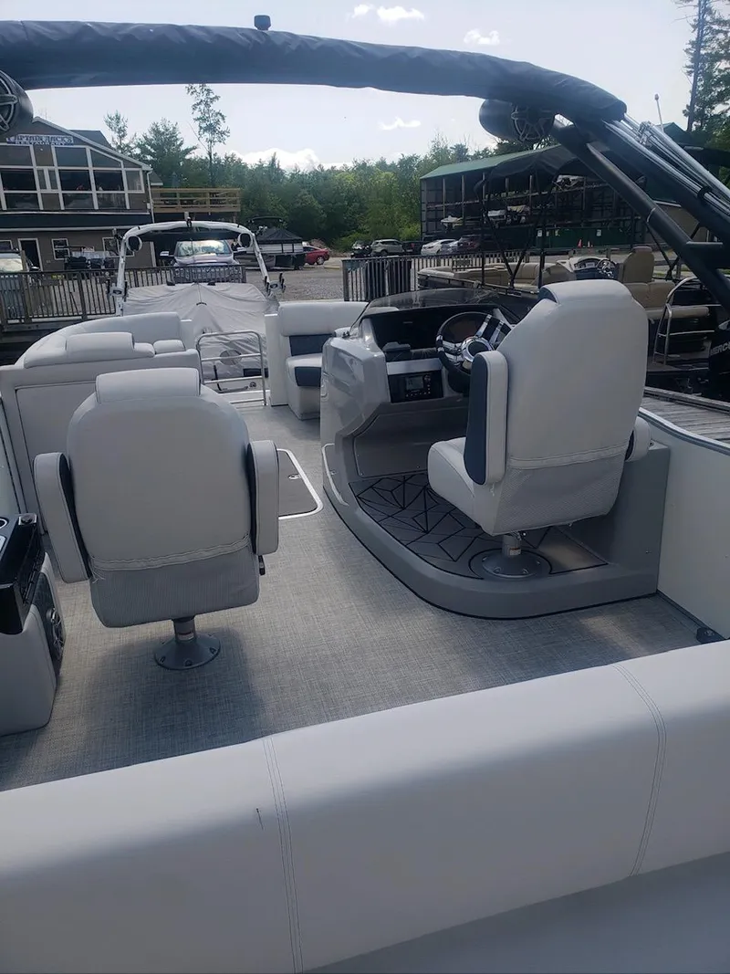Slide: The Image of 2023 Harris Grand Mariner 230 boat interior with white seating and modern dashboard. - 6