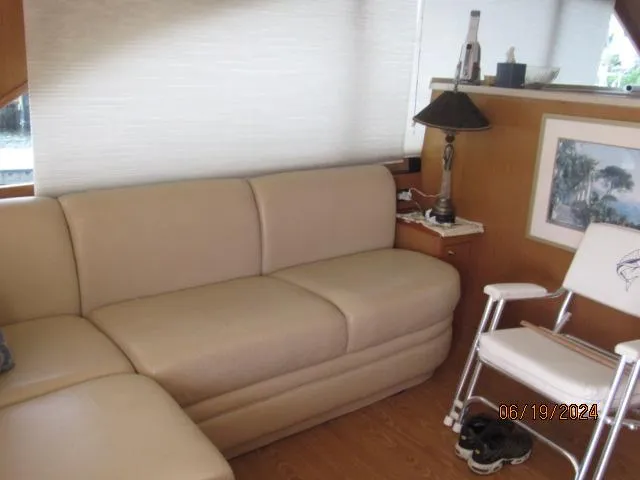 Slide: The Image of Interior of 2004 Ocean Yachts Super Sport with beige leather sofa and wooden decor. - 12