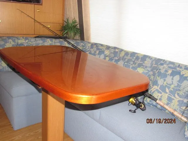Slide: The Image of Interior of 2004 Ocean Yachts Super Sport with wooden table and fishing rod. - 15