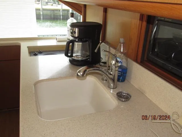 Slide: The Image of 2004 Ocean Yachts Super Sport kitchen sink with coffee maker and water bottle. - 16