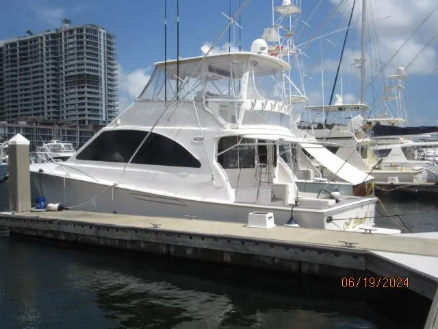 Slide: The Image of 2004 Ocean Yachts Super Sport docked at marina with high-rise buildings in background. - 2