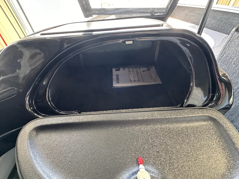 Slide: The Image of 2024 Smoker Craft Ultima 182 storage compartment with open hatch and key. - 10