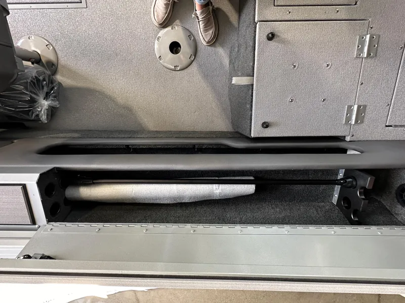 Slide: The Image of 2024 Smoker Craft Ultima 182 interior storage compartment with gray carpet and hinged access panel. - 16