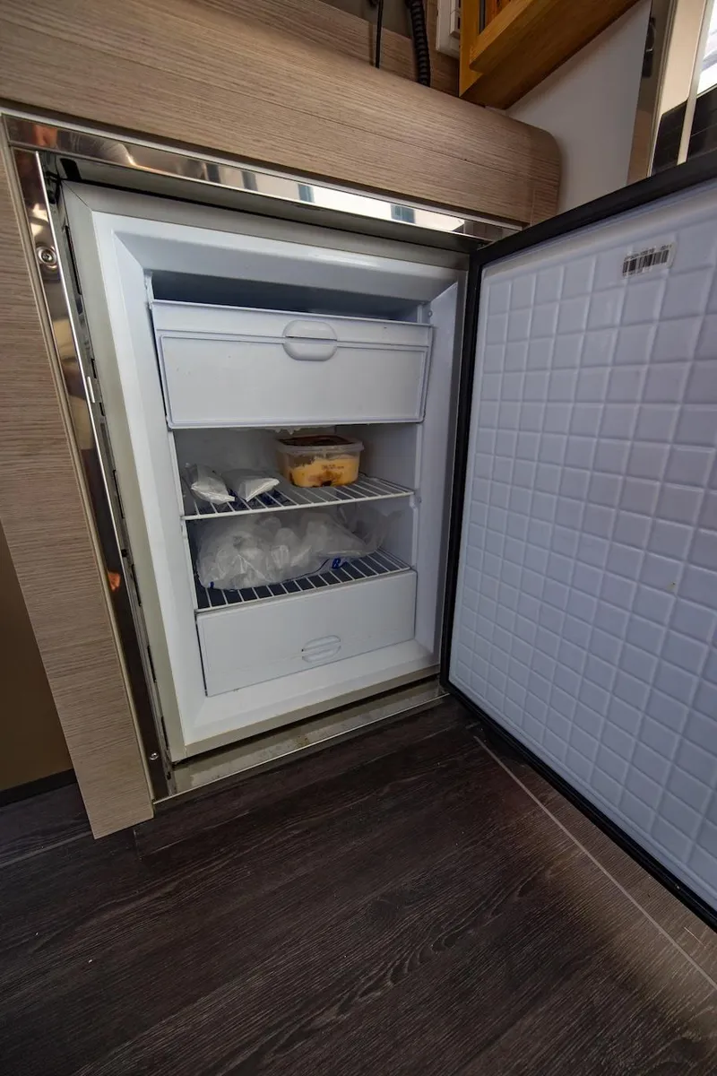 Slide: The Image of Open refrigerator on 2023 Fountaine Pajot Tanna 47 yacht, showcasing interior storage. - 23