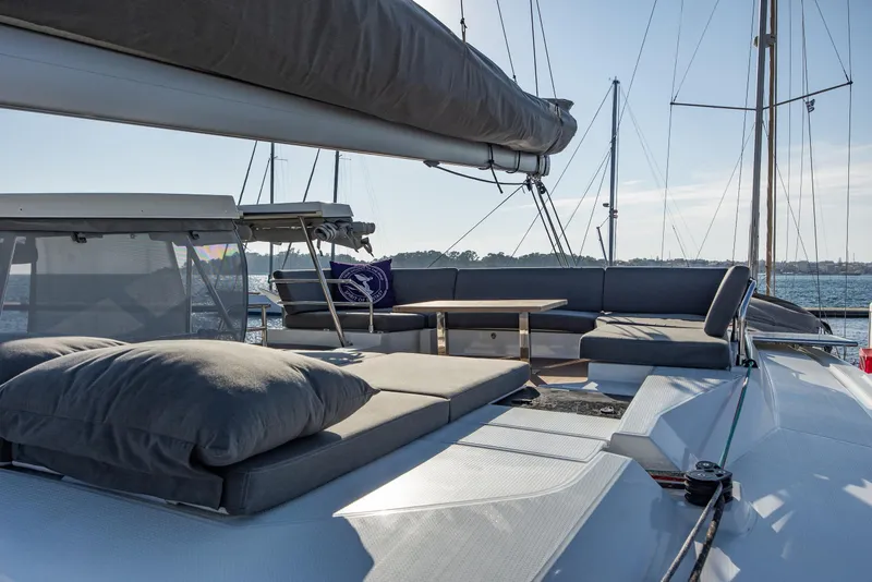 Slide: The Image of 2023 Fountaine Pajot Tanna 47 yacht deck with cushioned seating and table. - 8