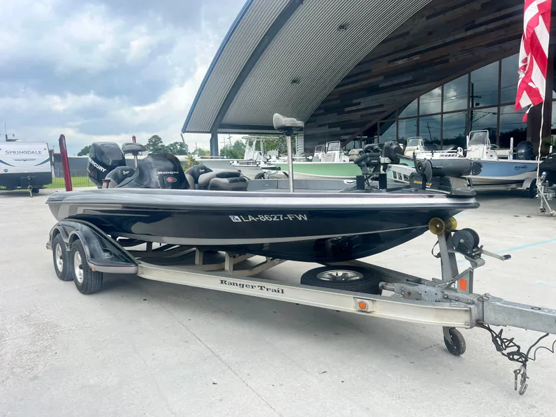 Slide: The Image of 2009 Ranger 208 VX boat on trailer outside a modern building. - 2
