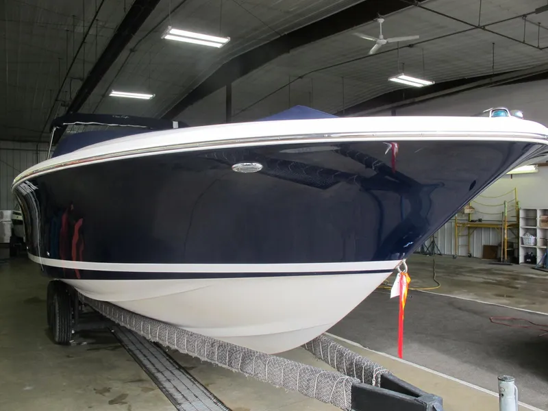 Slide: The Image of 2003 Chris-Craft Launch 28 boat in indoor storage on a trailer. - 2