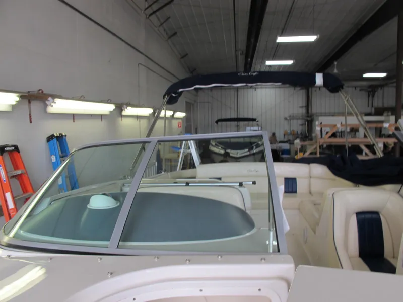 Slide: The Image of 2003 Chris-Craft Launch 28 boat with windshield and seating in a storage facility. - 6