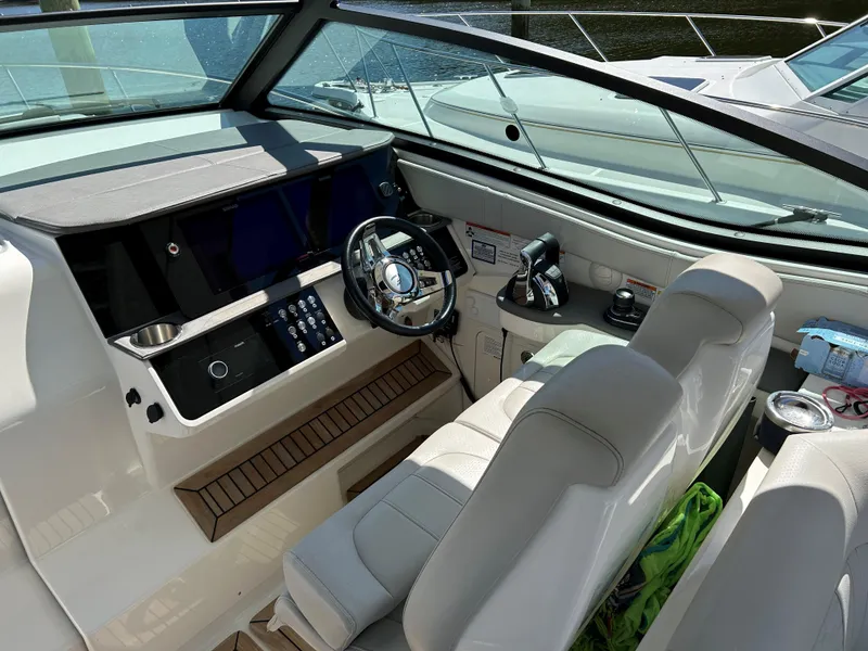 Slide: The Image of 2021 Sea Ray 320 DA boat cockpit with modern controls and comfortable seating. - 11