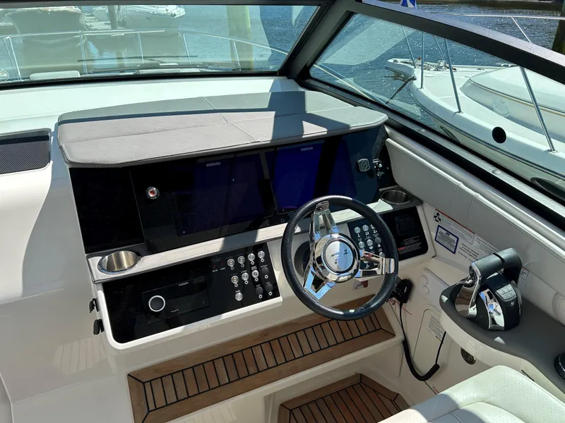 Slide: The Image of Cockpit of 2021 Sea Ray 320 DA boat with modern controls and steering wheel. - 12