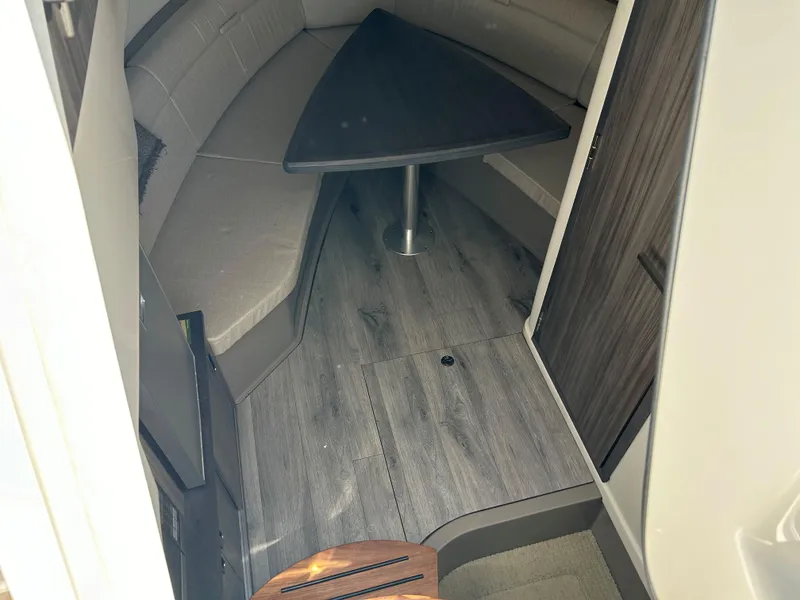 Slide: The Image of 2021 Sea Ray 320 DA cabin interior with wood flooring and triangular table. - 26
