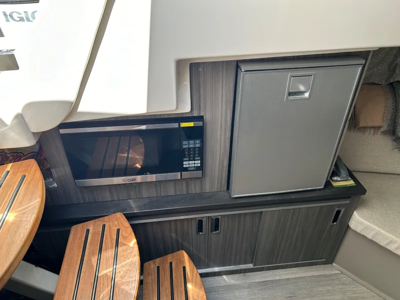 Slide: The Image of Sea Ray 320 DA 2021 boat interior with microwave and mini-fridge. - 29