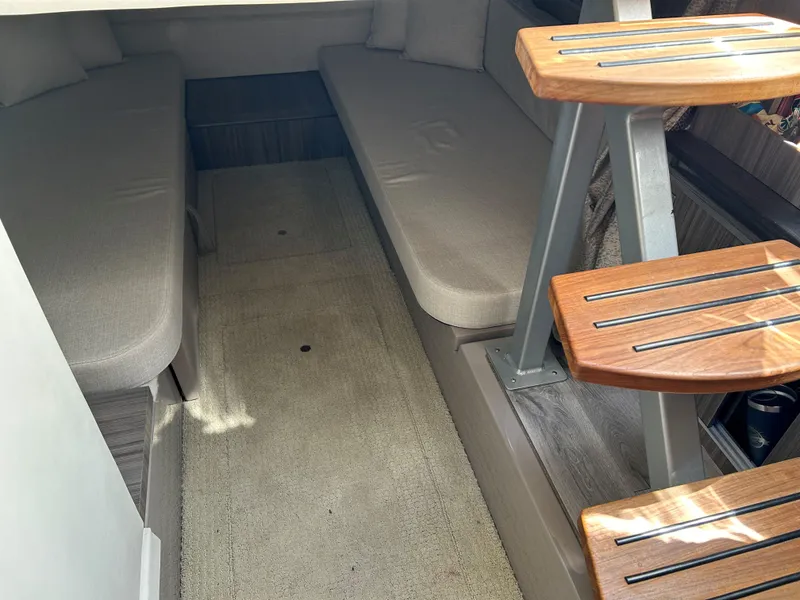Slide: The Image of Interior cabin of 2021 Sea Ray 320 DA with cushioned seating and wooden steps. - 32