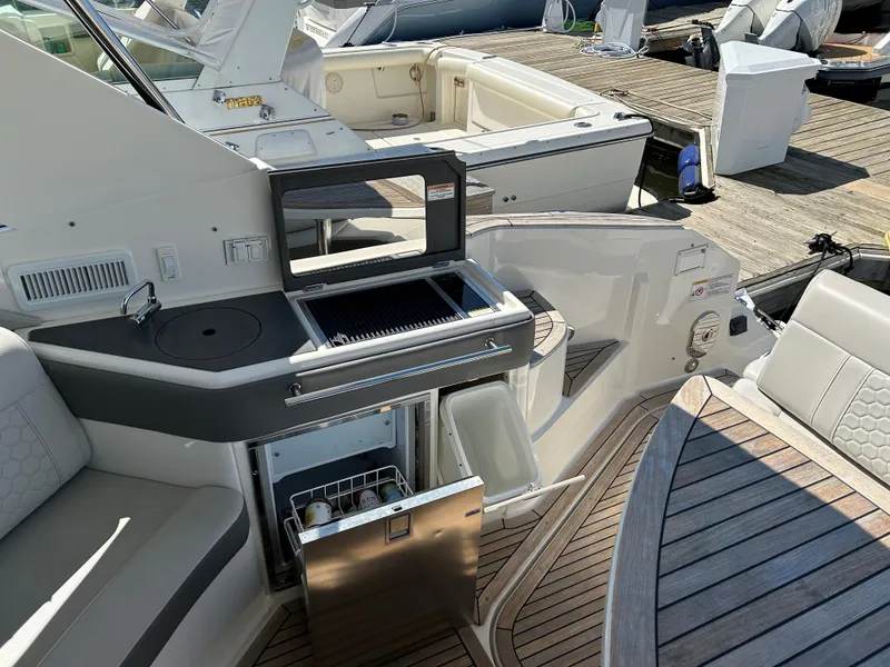 Slide: The Image of Sea Ray 320 DA 2021 boat interior with kitchenette and seating area. - 8