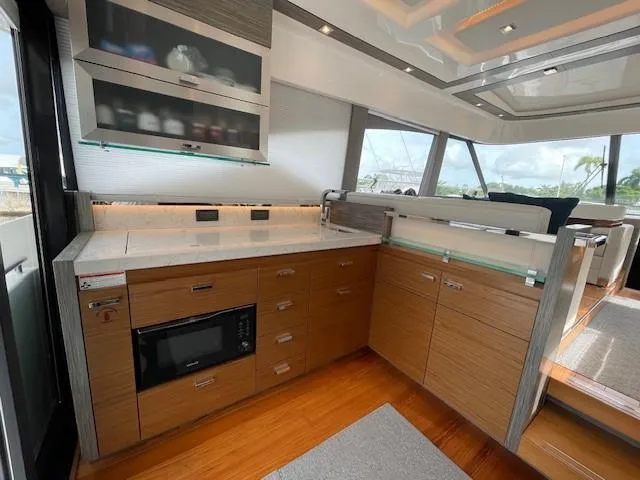 Slide: The Image of Modern kitchen area in 2019 Tiara Yachts C53 Coupe with wood cabinetry and sleek countertops. - 13